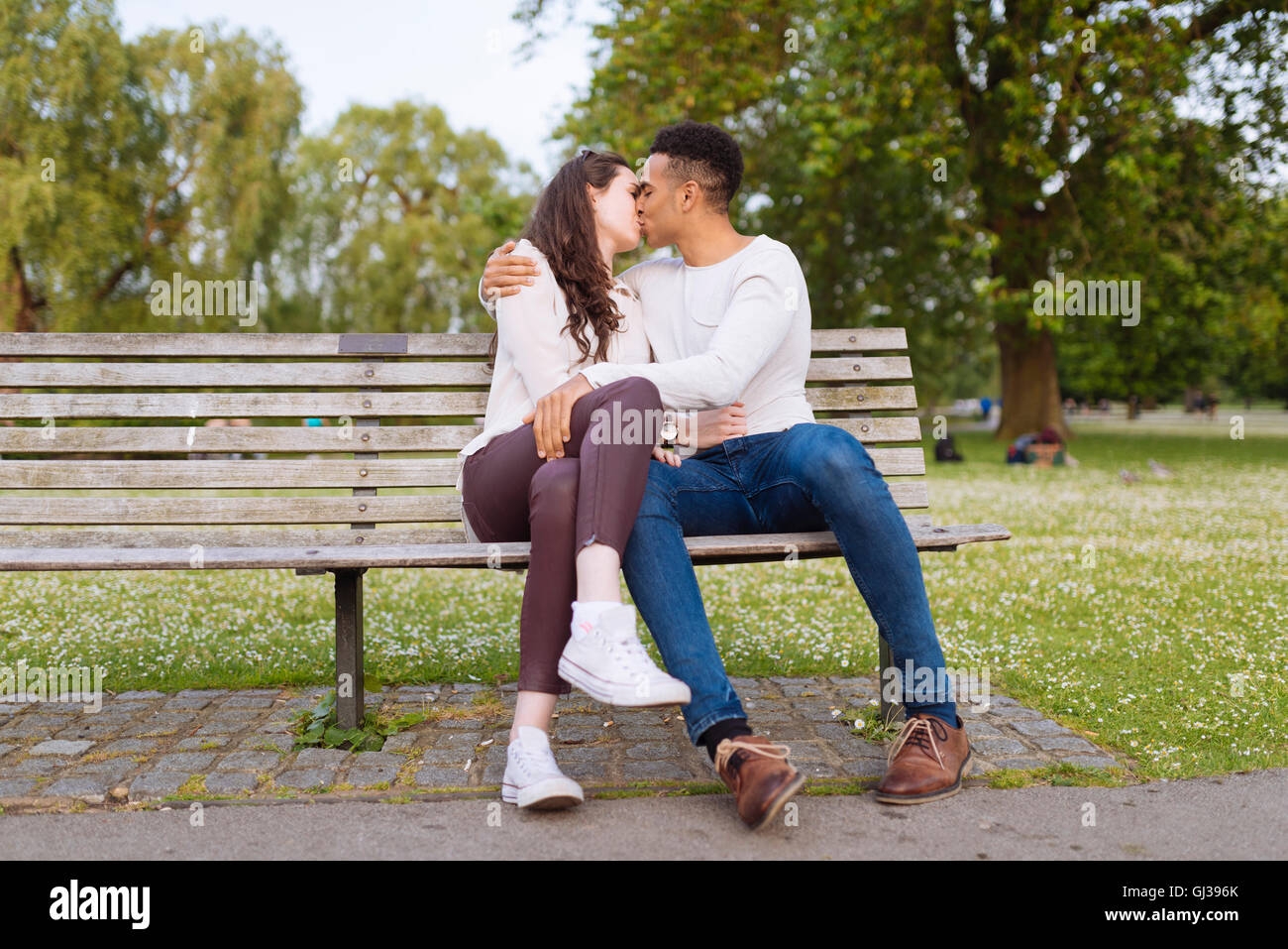 Young Couple On Park Bench Kissing Stock Photo Alamy